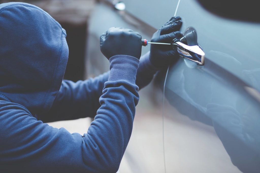 auto thief in hoodie and gloves