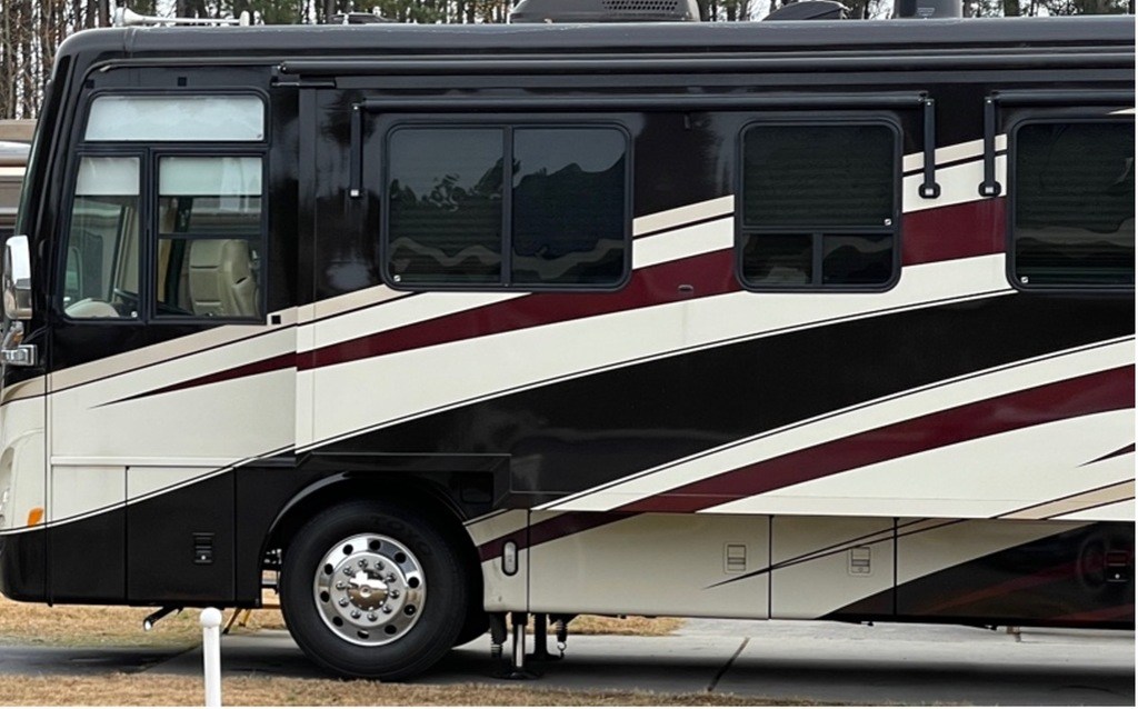 A black, red and white class A motorhome with slide out