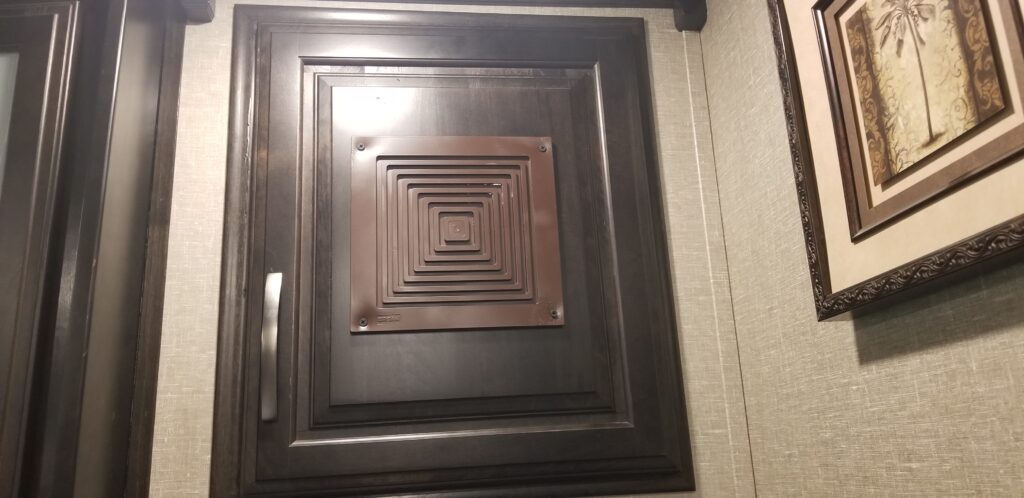 A vent inserted in cabinet door so fan has somewhere to push the heat