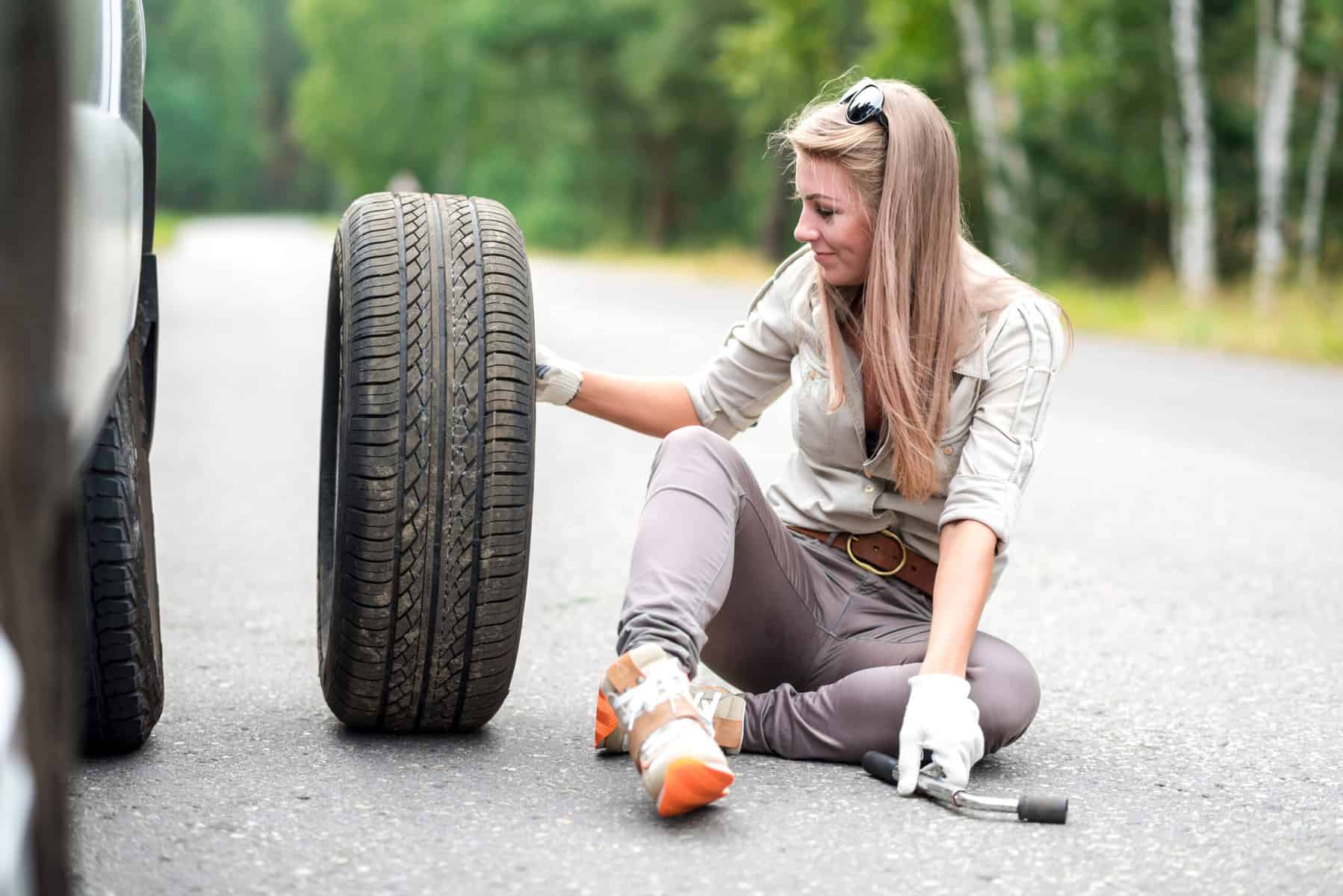 woman with tire using RV maintenance books for help
