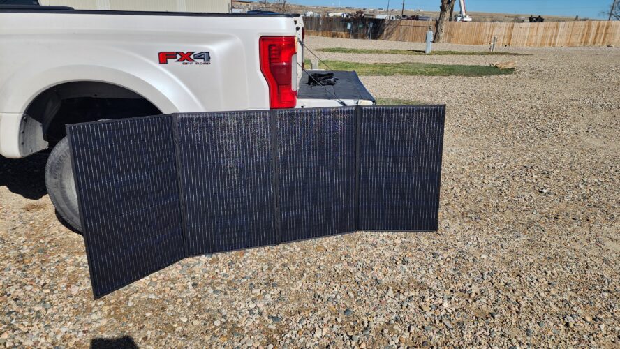 Bluetti PV350 solar array set up in the sun near the back of a truck at the campsite.